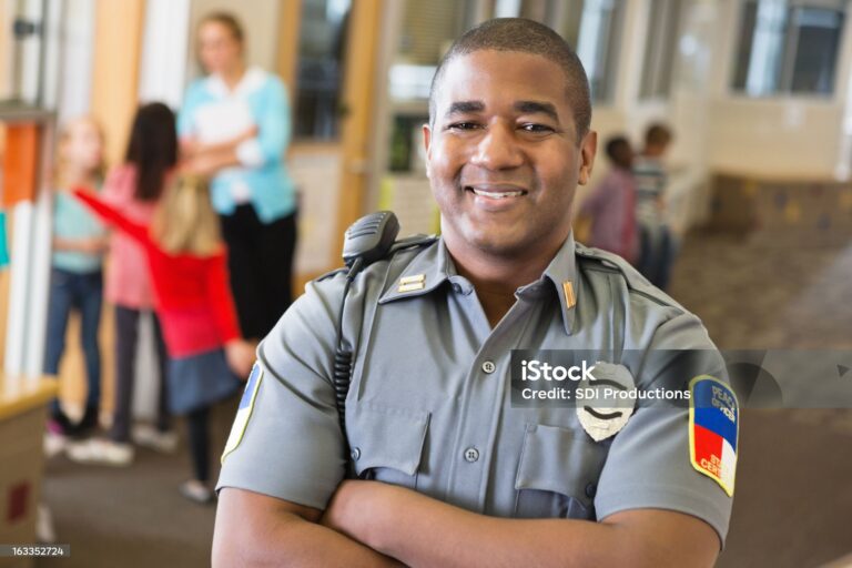 Smiling friendly police officer providing security on school campus